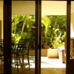 View of Lanai which seats 4 at the table.. There is a deck box filled with sand and water toys.